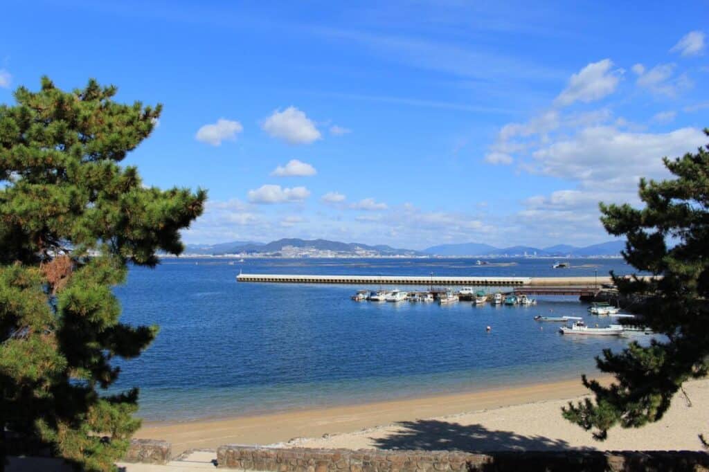 8 UNIQUE Miyajima Ryokans, Hiroshima 24 Calm beach with boats and trees.