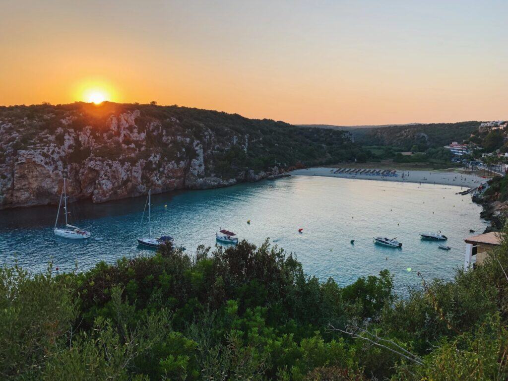 Exploring the Best Beaches in Menorca 12 Sunset over tranquil Cala en Porter, one of the best beaches in Menorca