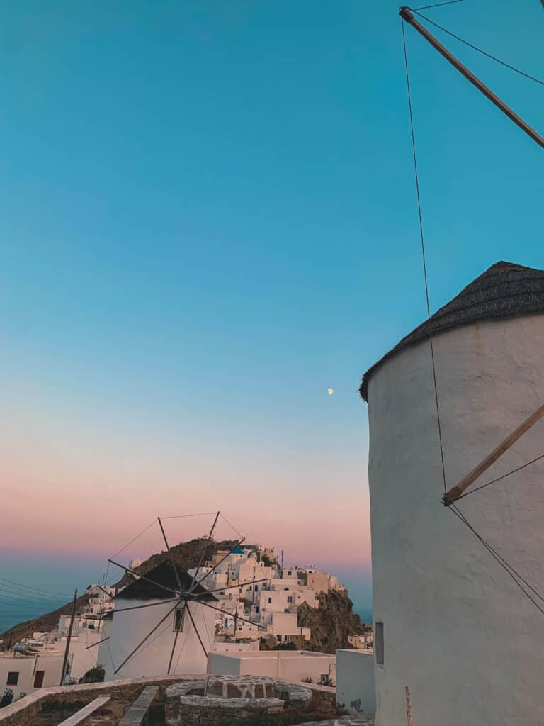 Windmill against pastel sunset sky in the center of a non touristy island in greece.