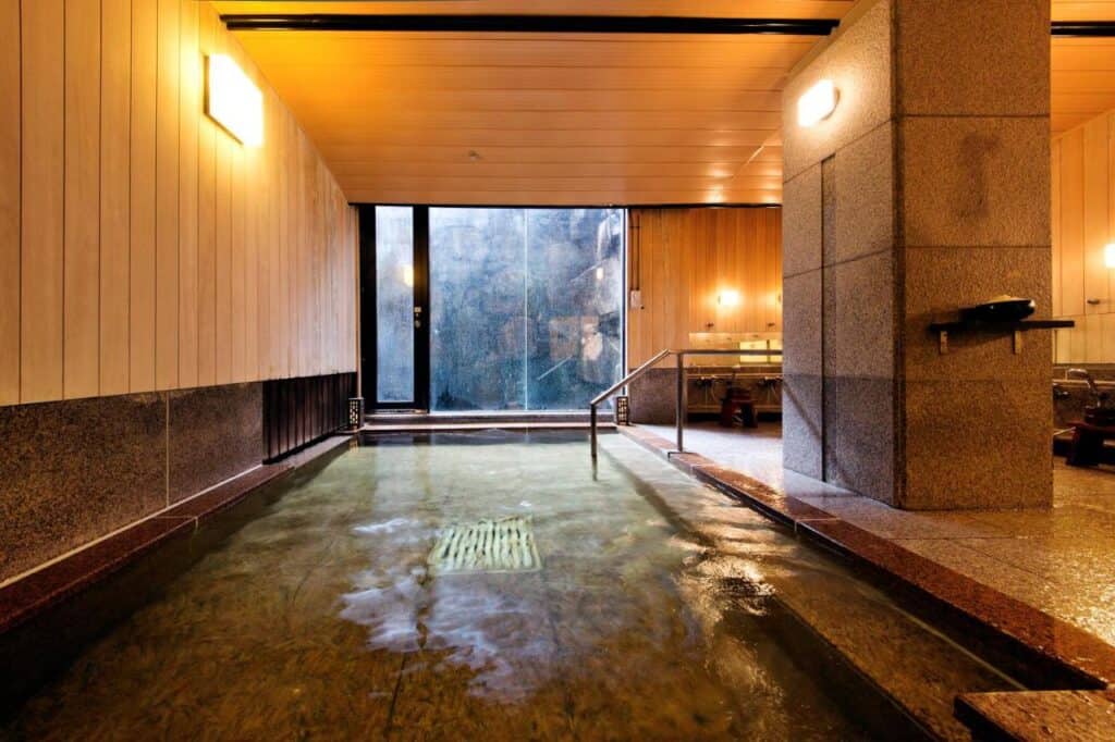 8 UNIQUE Miyajima Ryokans, Hiroshima 15 Serene indoor onsen bath experience.