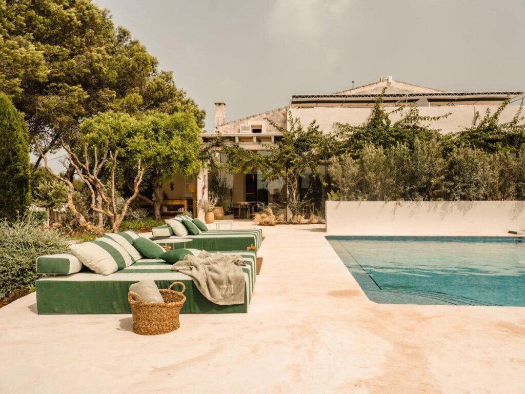 Exploring the Best Beaches in Menorca 9 Elegant poolside at Morvedra Nou hotel in Menorca with lush greenery.