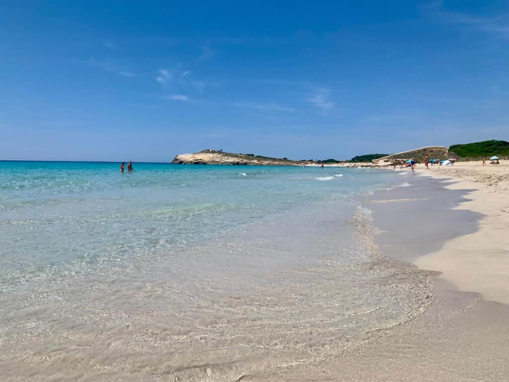 Exploring the Best Beaches in Menorca 13 Clear water and sandy beach scene at Son Bou beach in Menorca.