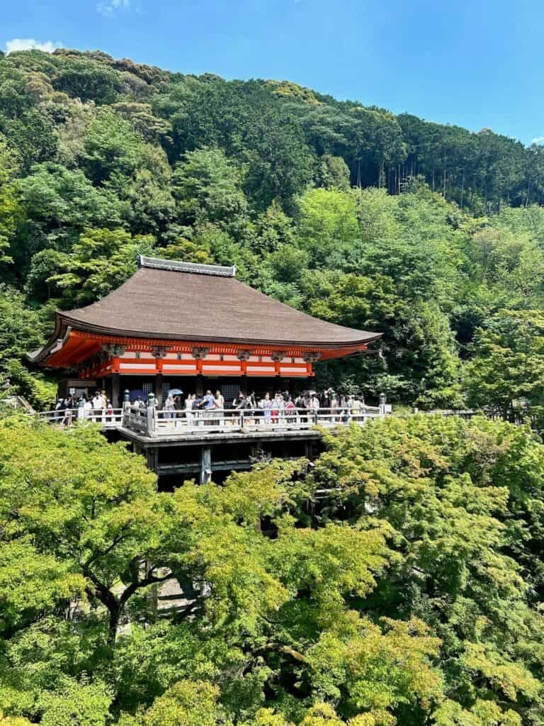 Traditional temple in Kyoto surrounded by lush greenery.