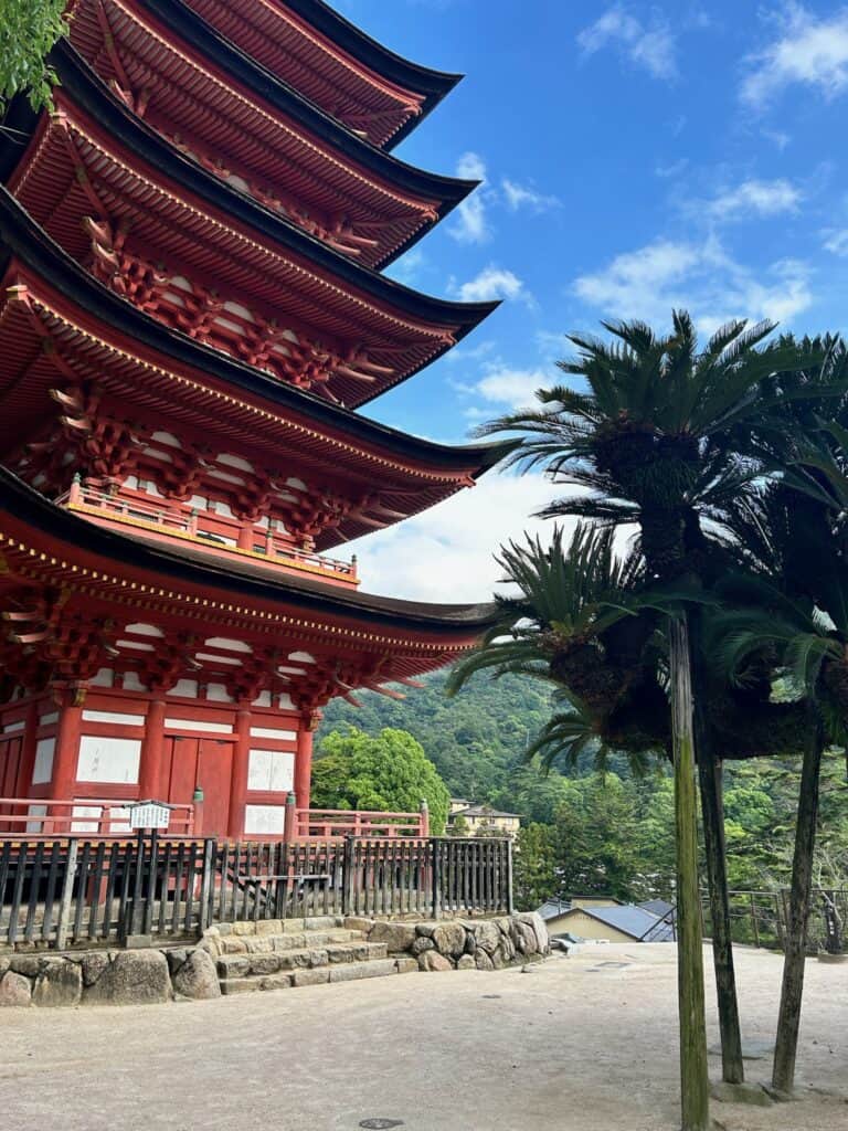 8 UNIQUE Miyajima Ryokans, Hiroshima 6 Red pagoda beside palm trees