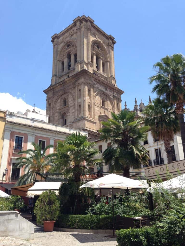 Granada in Two Days Itinerary: Local Guide 15 Historic tower amidst lush greenery.