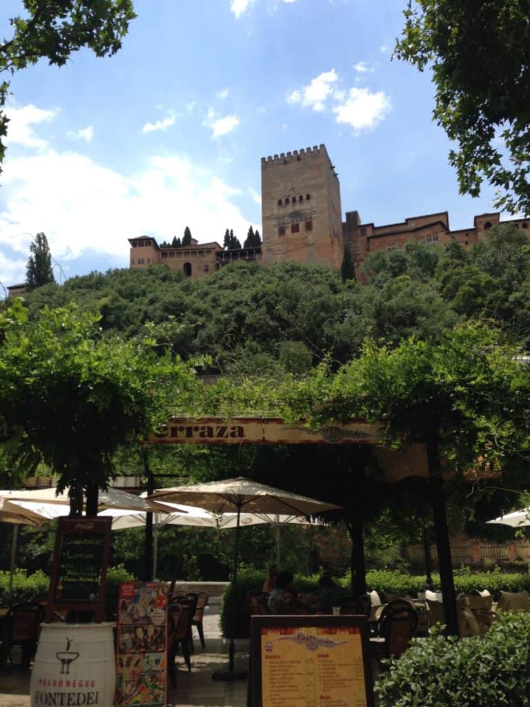 Alhambra fortress above lush greenery.