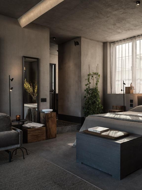 A modern, minimalist bedroom inspired by boutique hotels in Athens, with gray walls and furniture, large windows with sheer curtains, a bed with neutral bedding, a leafy plant, a tall mirror, and wooden accents for a serene, cozy vibe.